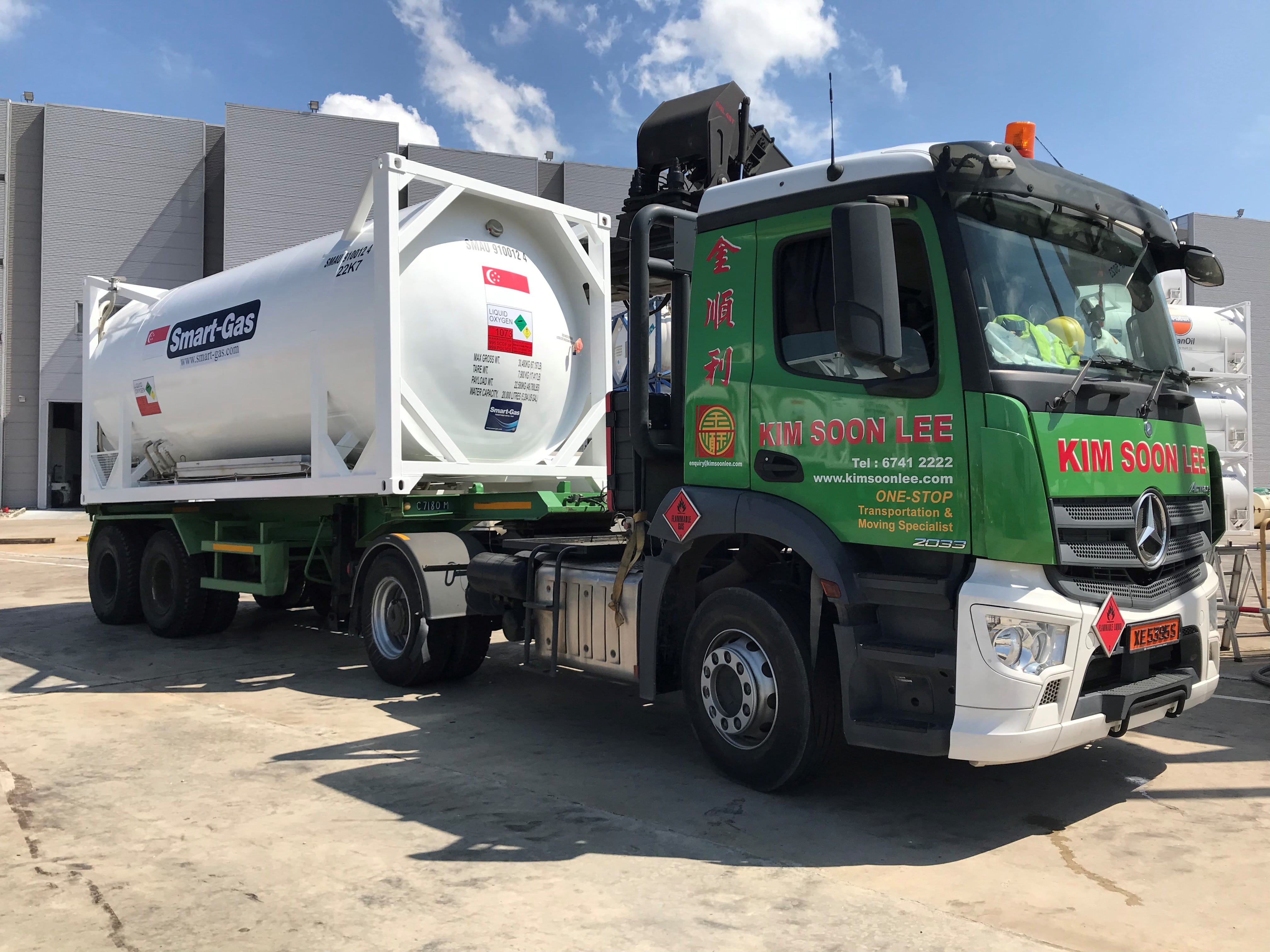 Two men in suits shake hands before flags of Singapore, Austria, and the European Union.